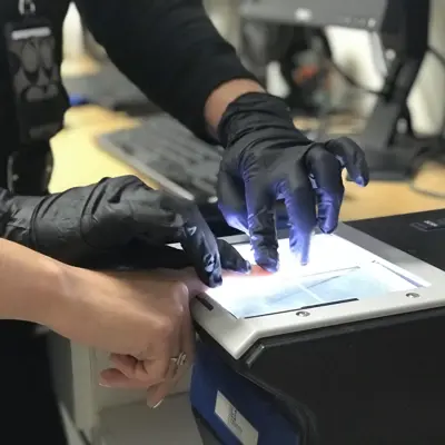 Official helps someone get fingerprinted